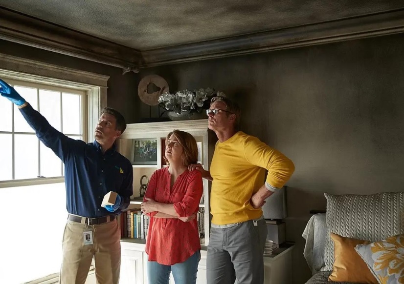 Professional smoke damage cleanup technician removing soot from walls and surfaces